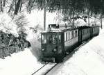 NStCM: ABDe 4/4 5 mit Regionalzug unterwegs unterhalb St-Cergue im Dezember 1984.