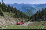 Bhe 1/2 22 fährt am 10. Mai 2015 oberhalb der Zwischenstation Ämsigen bergwärts. Im Hintergrund der Alpnacher- und der Vierwaldstättersee, sowie der Bürgenstock, die Rigi und das Gotthardmassiv.