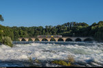 Ein einzelner GTW überfährt am Abend des 28. Juni 2016 die Brücke über den Rheinfall.