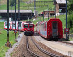 Glacier-Express (links nach St. Moritz) trifft Glacier-Express nach Zermatt: Kreuzung der beiden Panoramazüge in der Station Sumvitg-Cumpadials. Somvix, 31.7.2023