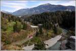 Blick von der Ruine Wackenau hinunter auf RE1244 mit der Ge 4/4 II 628  S-chanf  und den Dreibündenstein im Hintergrund.