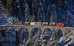 Die Ge 6/6 II 707  Scuol  überfährt mit einem Güterzug das Schmittentobelviadukt in Filisur.Bild vom 9.1.2017