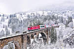 Am 15.12.2017 fährt die RhB Elektrolokomotive Ge 6/6 II 704  Davos  mit dem GEX 903 bei langsam sich verziehendem Nebel,nach starken Schneefällen am Vortag,über das Solisviadukt.