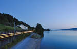 Die frühmorgendliche Ruhe wird soeben von einer BR 185 gar lärmig unterbrochen, welche mit einem RedBull-Ganzzug entlang des Zürichsees unterwegs ist.