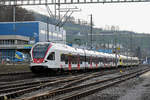 Doppeltraktion, mit den RABe 521 022 und 521 017 mit der Werbung für die Fachhochschule Muttenz, auf der S3, verlässt den Bahnhof Lausen.