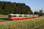 Be 8/8 23/24 fhrt am 9.7.10 mit dem Bt 203 im Schlepptau von Zollikerberg Richtung Waltikon. Diese Stelle hier kann man nur am frhen Morgen benutzten, danach wandert die Sonne auf die andere Seite der Geleise.