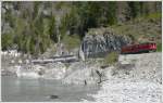 Ge 6/6 II 707  Scuol  bei der Hochwasserkurve zwischen Trin und Reichenau-Tamins. Wre die Lok nicht rot, man knnte den Zug glatt bersehen. (28.04.2010)