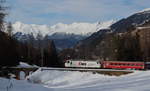 Vor schneebedeckten Bergen zieht die Ge 4/4 643 ihren Interregio Chur - St.Moritz bei Bergün bergwärts.

Bergün, 20. Februar 2020