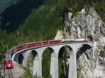 Eine Ge 4/4 III ziet einen RE von Chur nach St. Moritz ber das Landswasserviadukt.