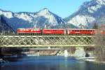RhB Schnellzug 555 von Chur nach St.Moritz am 27.02.1998 auf Rheinbrcke bei Reichenau mit E-Lok Ge 6/6 II 702 - D - 3x B - 2x A. Hinweis: gescanntes Dia
