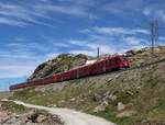 ABe 8/12 3511 „Otto Barblan“ hat mit dem Bernina Express 961 (Davos Platz – Tirano) die Passhöhe überwunden und rollt nun in Richtung Alp Grüm.