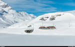 RhB Dampfschneeschleuderfahrt am 28. Januar 2018. <br>
Die Ge 4/4 182 schiebt die Xrotd 9213 von der ersten Schleuderfahrt bei der Wasserscheide zurück nach Ospizio Bernina dem schneebedeckten Lago Bianco entlang.