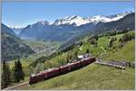 R4648 mit ABe 8/12 3511 fährt bei Cadera bergwärts Richtung Berninapass. Unten im Tal liegt Poschiavo, der Hauptort des Puschlav und der Lago di Poschiavo. Ganz hinten die Bergamasker Alpen im italienischen Veltlin. (07.05.2020)