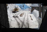 Blick aus dem 1. Klass-Abteil hinter dem Führerstand im Regionalzug von St. Moritz nach Tirano bei der Einfahrt in den Bahnhof Alp Grüm (2091 müM). Links wartet ein Oldie-Triebwagen in der alten Farbgebung der Berninabahn mit einem Arbeitszug auf seinen Einsatz. Alp Grüm, 19.2.2021