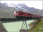 R1627 mit Gem 4/4 801  Steinbock  und ABe 4/4 II 44 kurz hinter Ospizio Bernina berquert einen Auslufer des Lago Bianco.