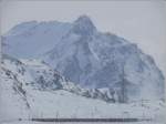 Verschwindend klein wirkt der BerninaExpress in dieser grandiosen Landschaft am Berninapass. (02.03.2009)
