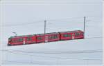 R1636 aus Tirano rauscht ber die tiefverschneite Alp Bondo Richtung St.Moritz.