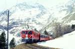 RhB Regionalzug 454 von Tirano nach St.Moritz am 09.03.1998 Einfahrt Alp Grm mit Triebwagen ABe 4/4 III 56 - B 2497 - B 2456 - B 2310 - DZ 4035 - Rw 8288 - Rpw 8272.