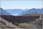 Bernina Express 973 zwischen Ospizio Bernina und Alp Grüm mit Blick Richtung Veltlin und Bergamasker Alpen.