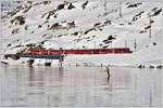 R1629 mit einem Allegra ABe 8/12 am schwarz gefrorenen Lago Bianco auf der Brücke am See bei Ospizio Bernina 2253m.