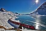 Der ABe 8/12 3505 Triebzug fährt mit einem Re nach St.Moritz am schwarzgefrorenen Lago Bianco entlang.Bild vom 28.12.2016