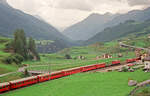 04. August 1991,Züge der RhB in Ardez auf der Linie Zernez - Samedan. Im Hintergrund die nach St. Moritz führende Straße 27