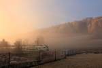 Aufgehende Sonne im Morgennebel, darin eingetaucht ein BLS  Mutz  als S-Bahn nach Bern.