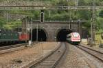 Ein Re 10/10 fahrt ins Gotthard-tunnel ein, weil ein ICN drausfahrt.