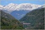 Der ICN 676 auf der Fahrt von Lugano nach Basel auf dem Pianotondo-Viadukt vor der beeindruckenden Kulisse des frisch verschneiten Gotthardmassiv.