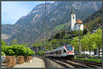 523 001 der SBB rollt am 22.04.2022 unterhalb der Pfarrkirche Herz Jesu durch Flüelen.