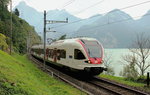 Zwischen Brunnen und Flüelen führt die Gotthardbahn zwar direkt am Vierwaldstättersee entlang, doch verlaufen große Teile im Tunnel. Vor allem bei nordwärts fahrenden Zügen tut sich aber dennoch die eine oder andere Lücke auf, wie hier am 15.09.2016 bei Gumpisch zwischen Flüelen und Sisikon mit dem RABe 523 004.