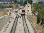 SFM, Bahnhof Enllac, bersicht Gleisanlagen mit ausfahrendem Zug nach Sa Pobla. Das linke Streckengleis fhrt nach Manacor. Links im Mittelgrund eine Plasser & Theurer Stopfmaschine. Foto: 02.07.2006