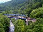 stadtbahn-karlsruhe-hier-nur-die-s-bahnen 01.06.2010: TW 910 und TW 811 als S31 von Menzingen / Odenheim nach Forbach. Hier �berqueren Sie die Murg kurz vor Langenbrand. Diese Br�cke war urspr�nglich eine gemauerte Bogenbr�cke. Im 2. Weltkrieg wurde der mittlere und gro�e Spannbogen �ber den Fluss gesprengt. Mit dem Wiederaufbau bekam diese Br�cke dann diesen Schwebetr�ger eingebaut. Mit dem Ausbau zur S-Bahn 2002 bekam er diesen blauen Anstrich. Das Bild wurde von der Stra�enbr�cke aufgenommen.
