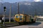 Gleisstopfmaschine steht in Innsbruck, im Hintergrund die Nordkette mit dem bekannten Hafelekar & der zugehrigen Seilbahn.
