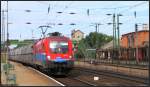 Die 1116 009 der Hungarian Cargo fährt mit einen Schüttgutwagenzug durch den Bahnhof von Komárom Anfang August 2015.