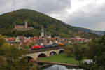 KT 62912 mit der ÖBB 1116 176 und einem Kombizug aus Sattelaufliegern und Containern passiert die Saalebrücke in Gemünden am Main mit Stadt und Burg im Hintergrund.