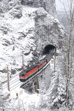 Bei herrlicher Winterstimmung verlassen 1144.098+1142.587 mit den stark verspäteten GAG-47041 den Weinzettelwand-Tunnel am 18.3.18