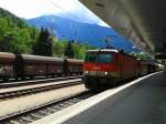 1144 025 + 1144 XXX mit einem Güterzug in Richtung Innsbruck am 25.7.2015 bei der Durchfahrt in Landeck-Zams.