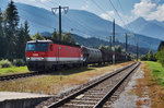 1144 090-8 fährt mit einem Güterzug, auf der Fahrt von Lienz in Richtung Spittal, in den Bahnhof Greifenburg-Weißenssee ein.
