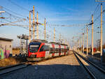 Wien. Als an diesem 16.02.2024 die letzten Sonnenstrahlen über dem Wiener Horizont verschwinden, fährt hier der 4024 056 in den Bahnhof Aspern Nord ein. 