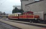 Im Gleisvorfeld des ehemaligen Salzburger Lokalbahnhofes steht im April 1983 eine der 1952 von SGP gebauten E-Loks mit zwei Beiwagen abgestellt