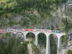 strecke-albulabahn-1-rei-fi Ein RE nach St. Moritz, der merkw�rdigerweise 5 Glacier Express Wagen und ein Wagen der Matterhorn-Gotthard Bahn vor den normalen Regio Wagen hatte f�hrt kurz vor Filisur �ber das Landwasserviadukt.