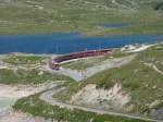 strecke-berninabahn-sm-ti Der R Tirano schl�ngelt sich am 7.7.2010 am Lago Bianco entlang.