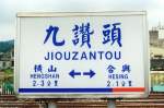 Stationsschild der Jiouzantou Station am 20.Mai 2005. Wie in sehr vielen Ländern Südost-Asiens üblich wird auch in Taiwan die Entfernung in km zur jeweils nächsten Verkehrsstelle angegeben.