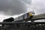 MRT YM12 (Hersteller: Bombardier Transportation + CRRC Nanjing Puzhen, Type Innovia Monorail 300) fährt am 28.September 2023 unter tropischen Monsunwolken in die Hua Mak Station (YL11).