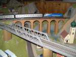 Modellbahn von Christian Maier Der MWB Taurus mit Silberlingen auf dem Steinbogenviadukt.