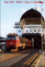 mz In August 1991, die Mz 1403 zieht einen regionalen Zug aus dem F�hrschiff Dronning Ingrid. Auf dem Schiff sind drei bis vier IC3 Einheiten auf zwei Gleisen und mehrere RIC Wagen (8 - 10) auf die zwei andere Gleisen. Die IC3 haben Vorrang und fahren zum ersten als IC mit Zuschlag, dann kommen die Wagen f�r den zweiten Zug, ohne Zuschlag, beiden auf der Strecke Kopenhagen - Fredericia (und Esbjerg - Aarhus). 
Foto und copyright : J.J. Barbieux