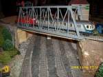 Anlagen FLEISCHMANN`s 212 und ein Silberlingsteuerwagen �berqueren �ber eine Br�cke das Industriegebiet.