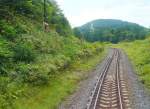 ehemstaatsbahn-jr-intercity-zuge KIHA 261: Aus dem Zug KIHA 261-101 aufgenommen - Abstieg am Shiokari-Pass vom wilden, von Zivilisation kaum ber�hrten Nord-Hokkaido in die Ebene des zentralen West-Hokkaido. Die modernen Z�ge KIHA 261 mit neigbarem Wagenkasten schaffen hier eine beachtliche Beschleunigung. 28.August 2008.