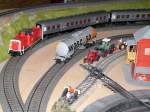 Modellbahn von Christian Maier Die V 100 mit den Silberlingen bei der Einfahrt in den Bahnhof auf dem Abstellgleis ist ein Wascosa Kesselwagen abgestellt.